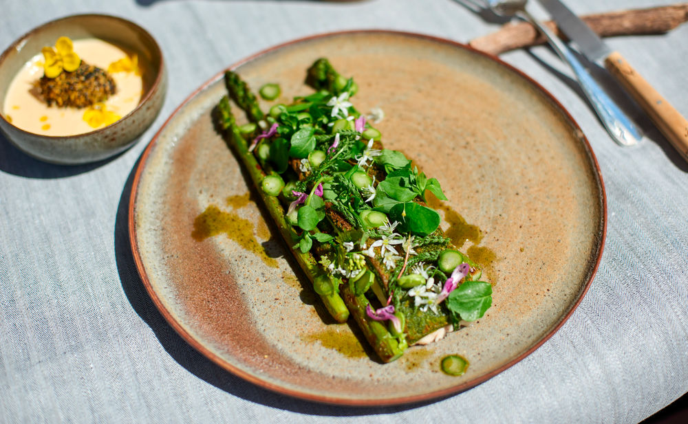 Überbackener Saibling mit Spargel, Wildkräutern und Rapserdäpfeln